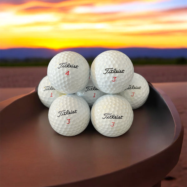 Återvunna golfbollar av modellen Titleist MIX i vit färg fotade framifrån 